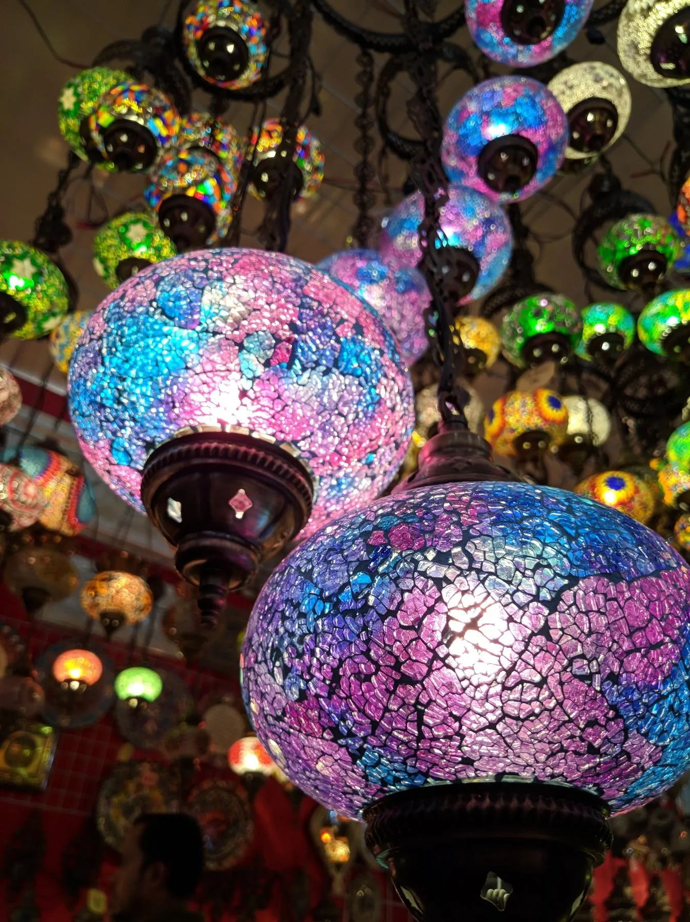 Colourful mosaic glass lamps glowing in pink, blue and green, photographed by Maruf